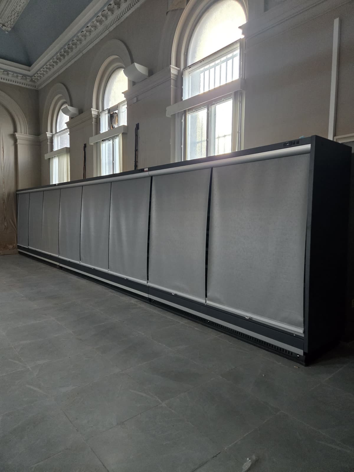 Multideck chiller run installed along the wall of a high-ceilinged period building